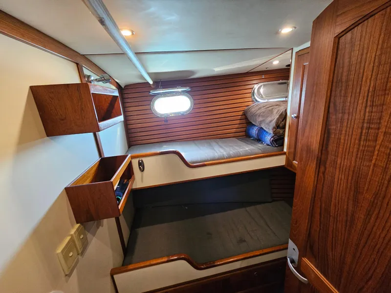 Slide: The Image of 2002 Nordhavn Trawler cabin with wooden interior and bunk beds. - 31