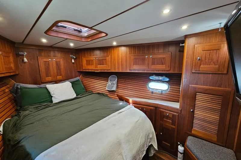 Slide: The Image of Luxurious 2002 Nordhavn Trawler cabin with wood paneling and cozy bedding. - 35