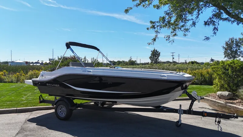The Image of A 2025 Bayliner D20I boat on a trailer in a green setting. - 0