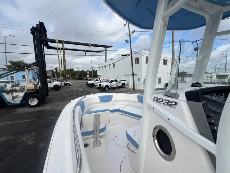 Slide: The Image of 2025 Robalo 232 Explorer boat at a marina, featuring sleek design and modern amenities. - 11
