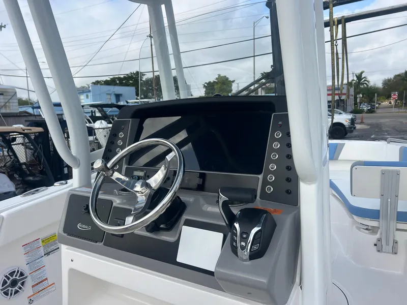 Slide: The Image of 2025 Robalo 232 Explorer boat dashboard with steering wheel and control panel. - 16