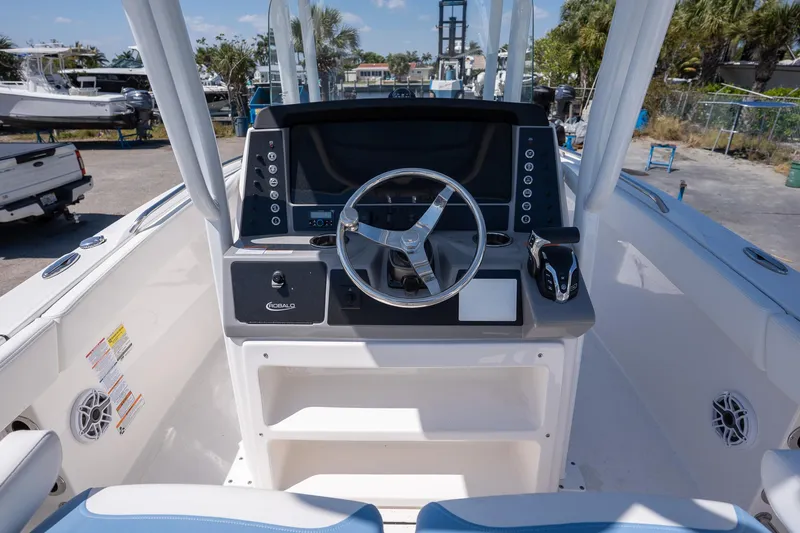 Slide: The Image of 2025 Robalo 232 Explorer boat dashboard with steering wheel and control panel. - 17