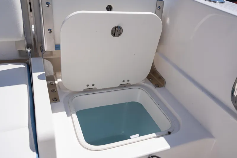 Slide: The Image of 2025 Robalo 232 Explorer boat storage compartment with open hatch. - 24