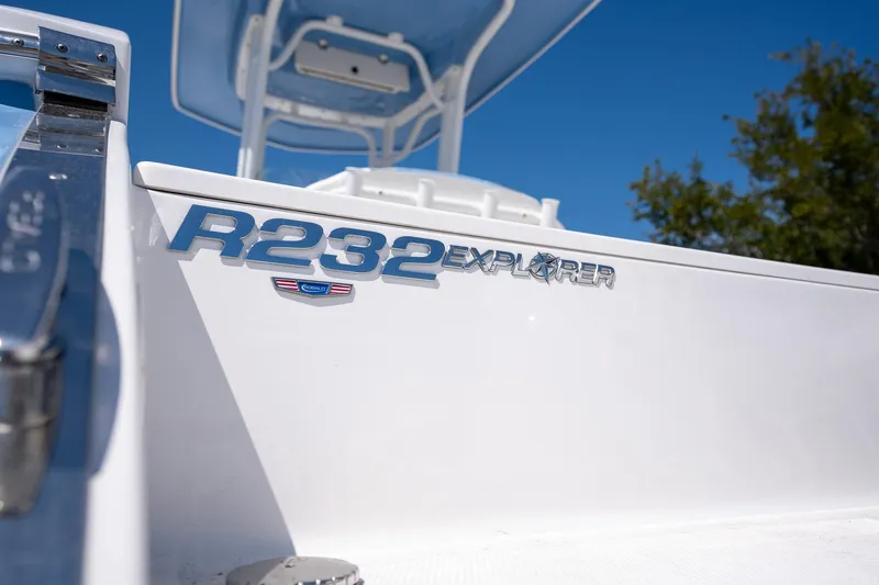 Slide: The Image of 2025 Robalo 232 Explorer boat, close-up of model name on white hull. - 25