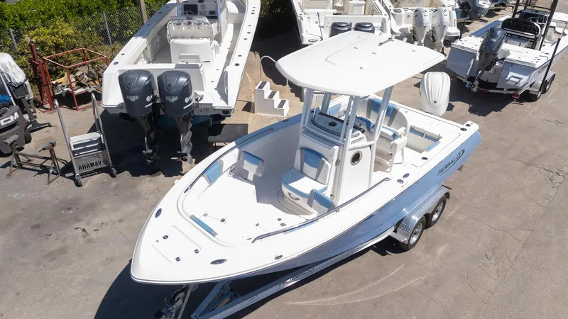 Slide: The Image of 2025 Robalo 232 Explorer boat on trailer, surrounded by other boats in a marina. - 29