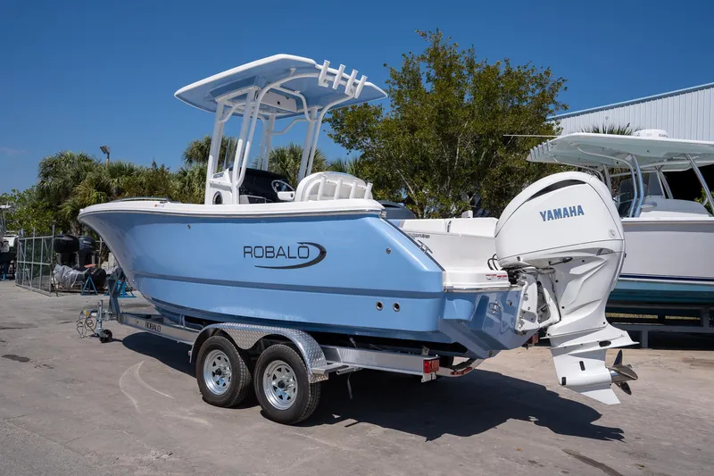 Slide: The Image of 2025 Robalo 232 Explorer boat with Yamaha engine on trailer, parked outdoors. - 3