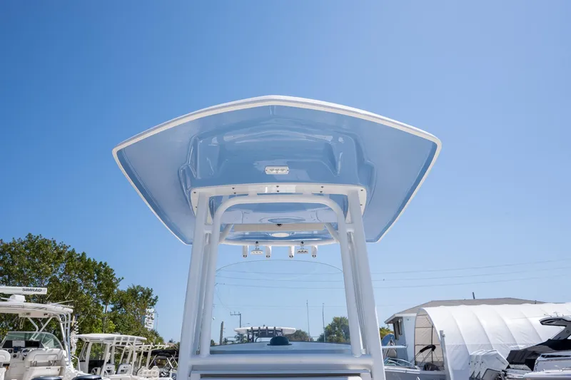 Slide: The Image of 2025 Robalo 232 Explorer boat with T-top against clear blue sky. - 8