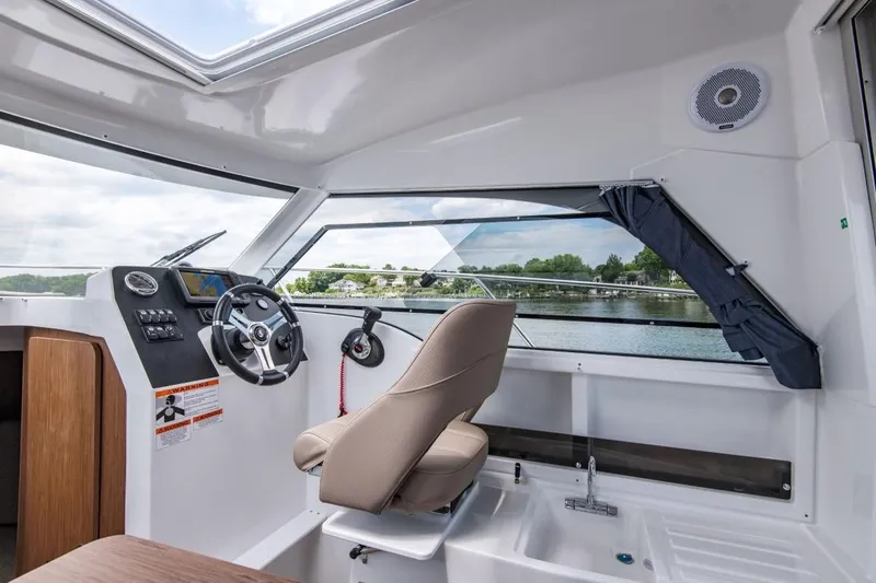 Slide: The Image of 2025 Beneteau Antares 7 interior cockpit with steering wheel and panoramic windows. - 10