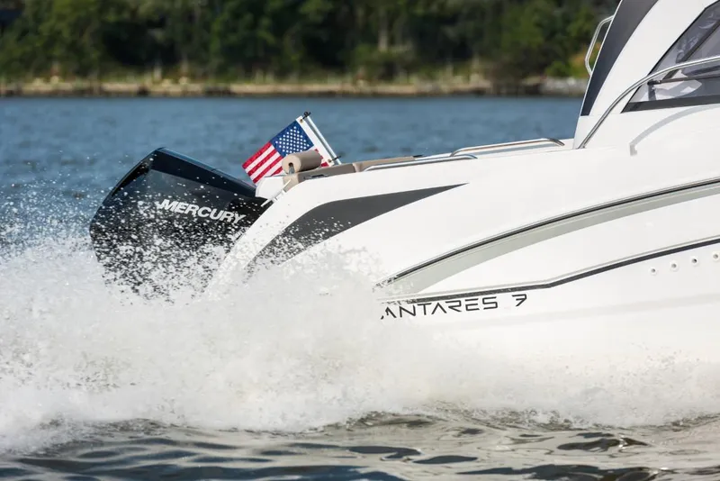 Slide: The Image of 2025 Beneteau Antares 7 boat cruising with Mercury engine, American flag visible. - 12