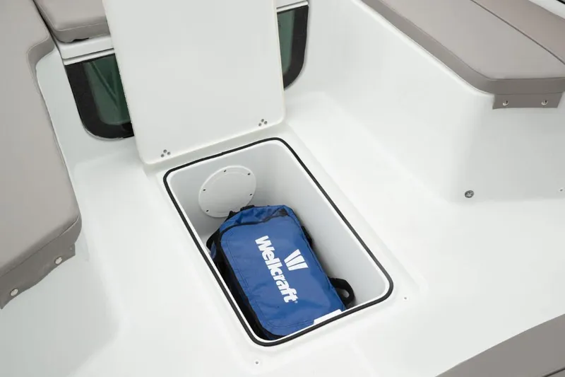 Slide: The Image of 2025 Wellcraft 202 Fisherman boat storage compartment with blue Wellcraft bag inside. - 13