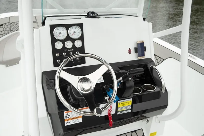 Slide: The Image of 2025 Wellcraft 202 Fisherman boat dashboard with steering wheel and gauges. - 15