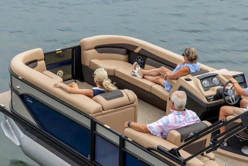 Slide: The Image of 2025 Barletta Cabrio 24UC pontoon boat cruising on a lake with passengers. - 10