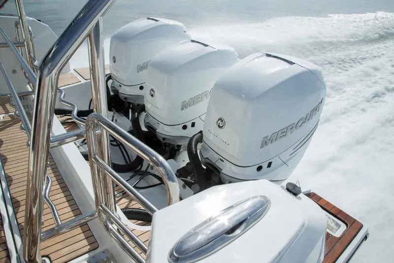 Slide: The Image of Triple Mercury outboard engines on 2025 Wellcraft 38 Explorer boat, cruising on water. - 11