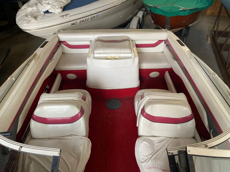 Slide: The Image of 1995 Wellcraft 196 S Eclipse boat interior with red and white seating, stored indoors. - 14