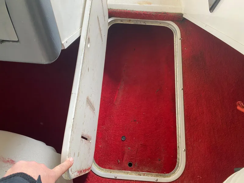 Slide: The Image of Red carpeted interior of a 1995 Wellcraft 196 S Eclipse boat with open storage hatch. - 16