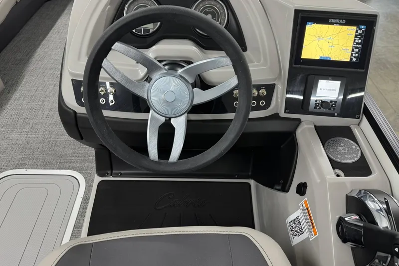 Slide: The Image of 2025 Barletta Cabrio 24UC boat dashboard with steering wheel and navigation display. - 13