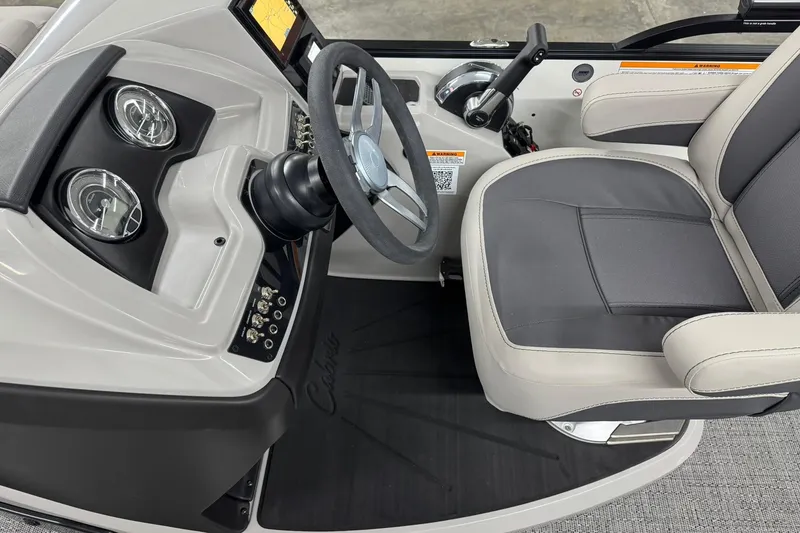 Slide: The Image of 2025 Barletta Cabrio 24UC boat cockpit with steering wheel and comfortable seating. - 14