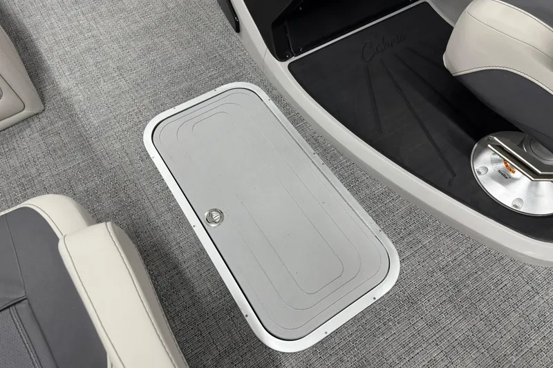 Slide: The Image of 2025 Barletta Cabrio 24UC boat interior with gray flooring and storage compartment. - 18