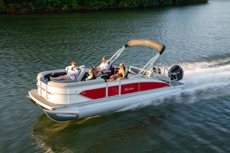 Slide: The Image of 2025 Barletta Cabrio 24UC pontoon boat cruising on a lake with passengers. - 4