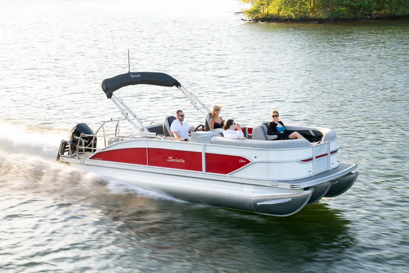 Slide: The Image of 2025 Barletta Cabrio 24UC pontoon boat cruising on a lake with passengers. - 6