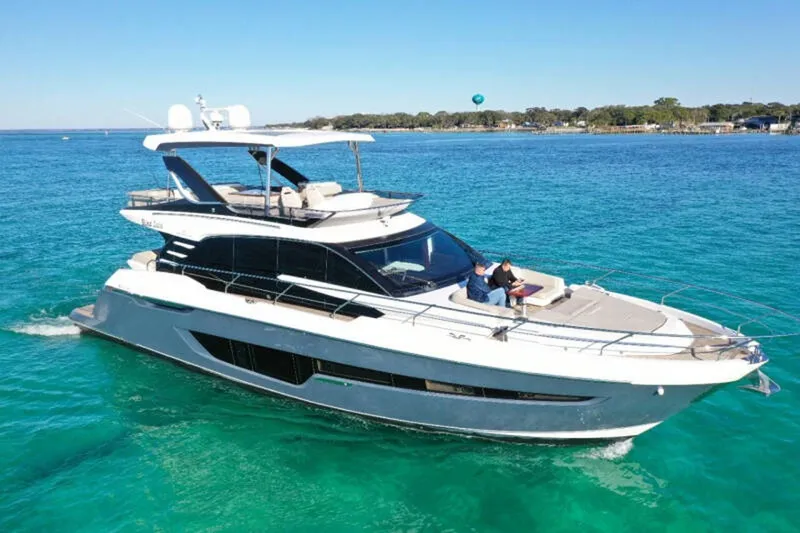 Slide: The Image of 2020 Fairline Squadron 68 yacht cruising on clear blue water. - 1
