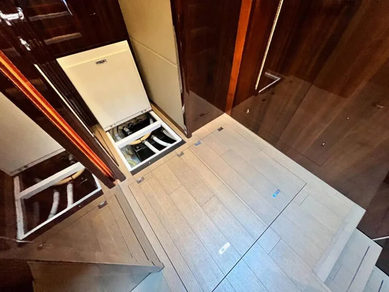 Slide: The Image of Engine room access on 2020 Fairline Squadron 68 yacht, featuring wooden flooring and open hatches. - 23