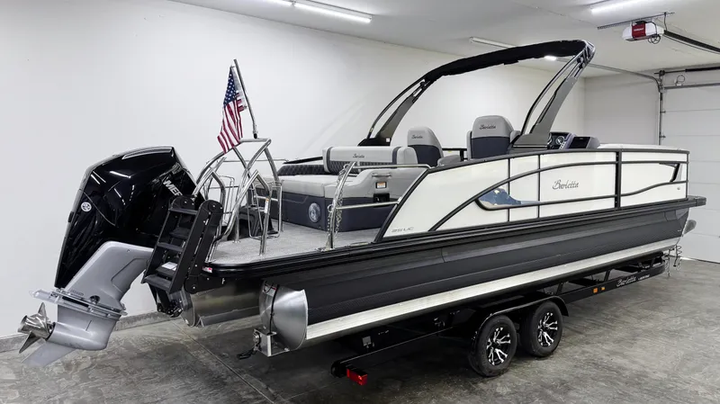 Slide: The Image of 2025 Barletta Lusso 25UC pontoon boat in showroom, featuring sleek design and powerful outboard motor. - 3