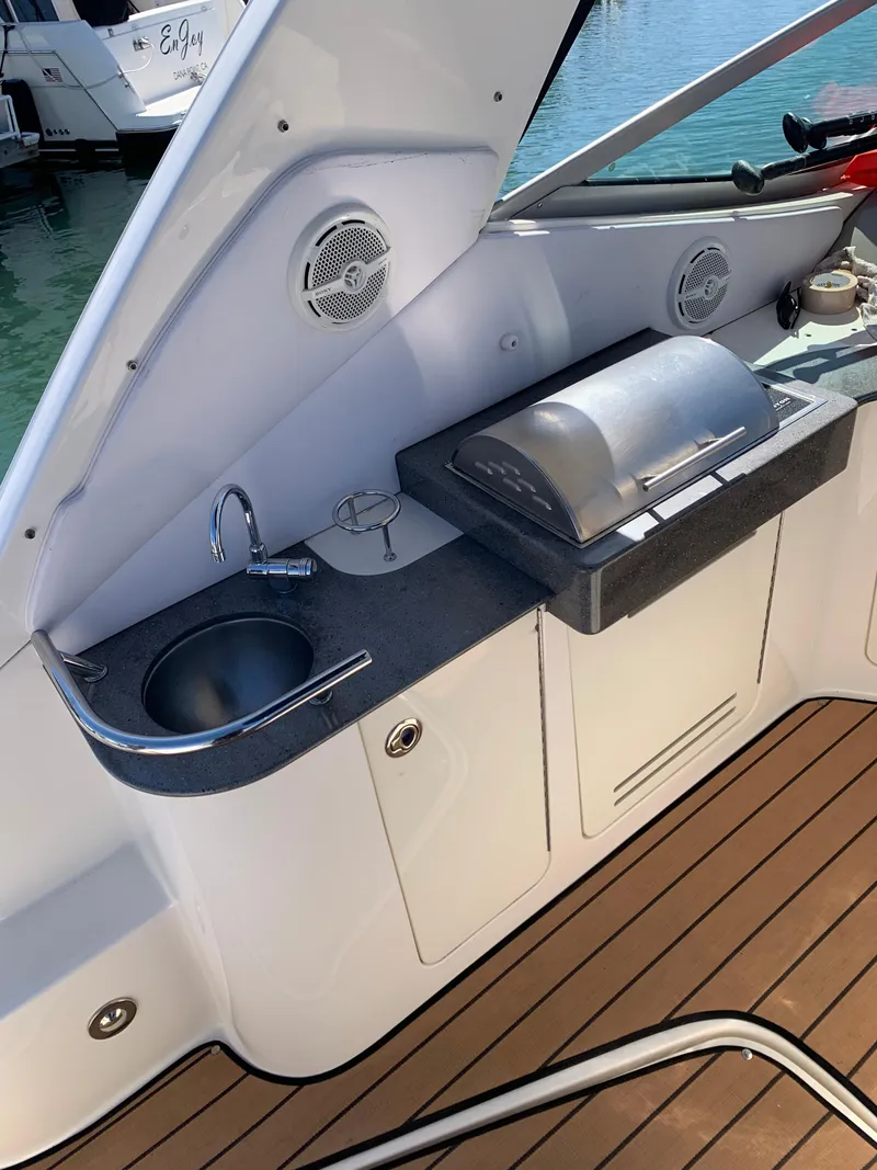 Slide: The Image of 2011 Sea Ray 330 Sundancer boat kitchenette with sink and grill on deck. - 1