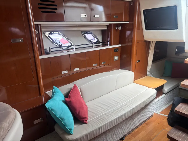 Slide: The Image of Interior of 2011 Sea Ray 330 Sundancer with modern seating and wood finishes. - 24