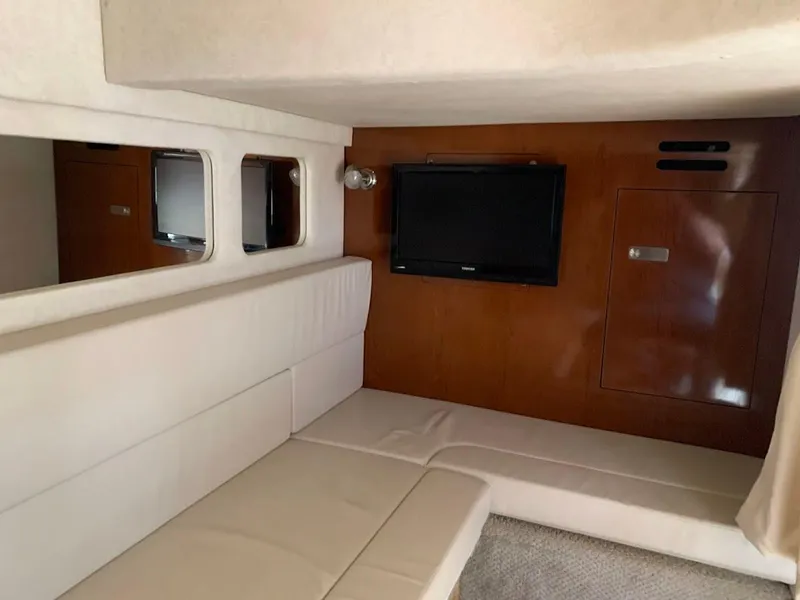 Slide: The Image of Interior of 2011 Sea Ray 330 Sundancer with beige seating and wall-mounted TV. - 33