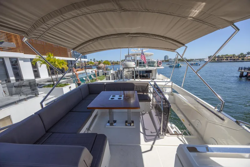 Slide: The Image of Flybridge of 2018 Prestige 520 yacht with seating and table, docked by waterfront homes. - 36