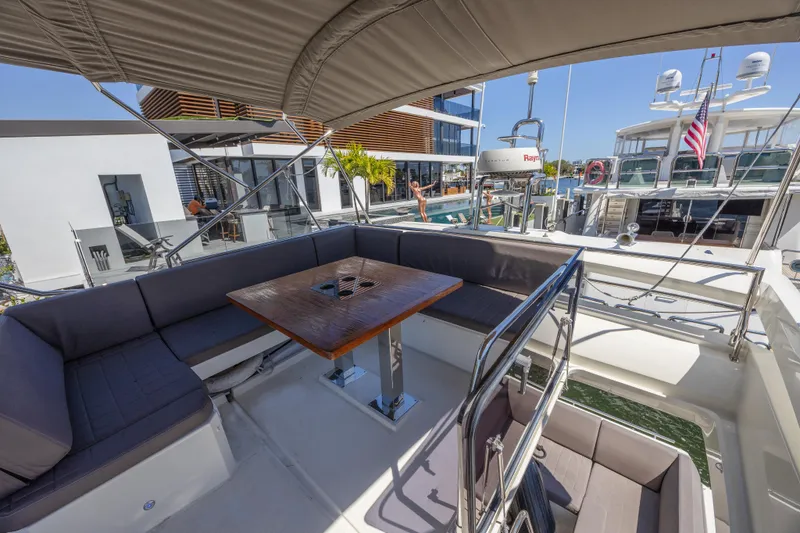 Slide: The Image of Prestige 520 yacht 2018 model, featuring a spacious outdoor seating area with a wooden table. - 37