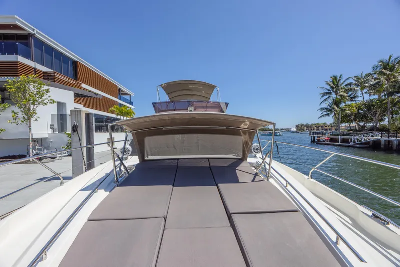 Slide: The Image of 2018 Prestige 520 yacht docked by waterfront, featuring spacious sunbathing area and modern design. - 47