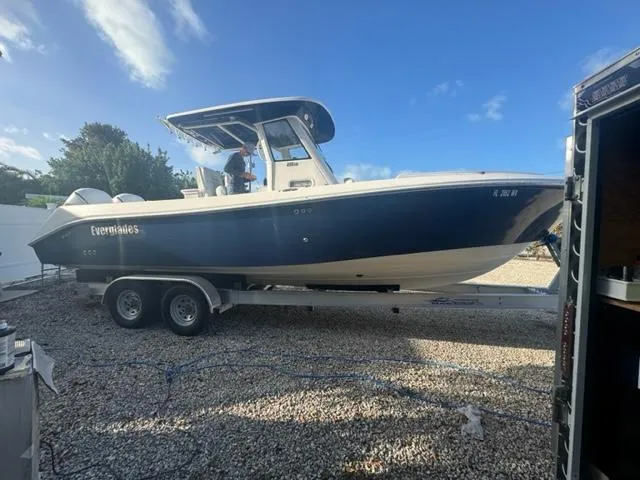 Slide: The Image of 2015 Everglades 295 Center Console boat on trailer, parked outdoors under blue sky. - 0