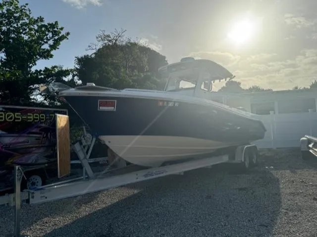 Slide: The Image of 2015 Everglades 295 Center Console boat on trailer in sunny outdoor setting. - 1