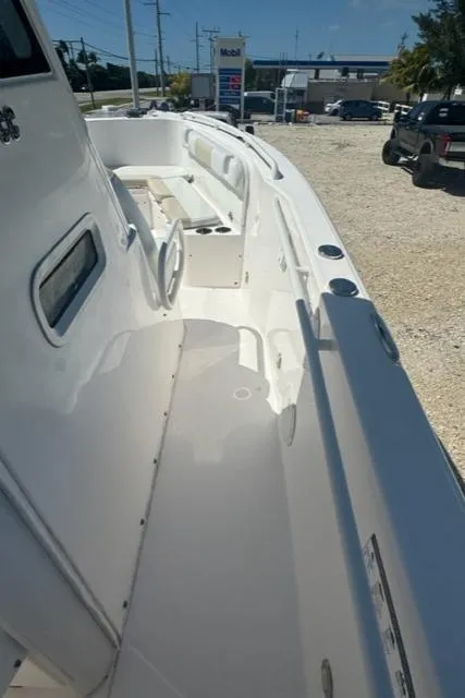 Slide: The Image of 2015 Everglades 295 Center Console boat, white deck view, parked outdoors. - 29