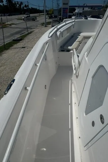 Slide: The Image of 2015 Everglades 295 Center Console boat deck, featuring sleek white design and spacious layout. - 30