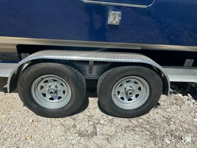 Slide: The Image of Trailer wheels for 2015 Everglades 295 Center Console on gravel surface. - 44