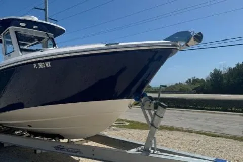 Slide: The Image of 2015 Everglades 295 Center Console boat on trailer, blue and white design, parked outdoors. - 5