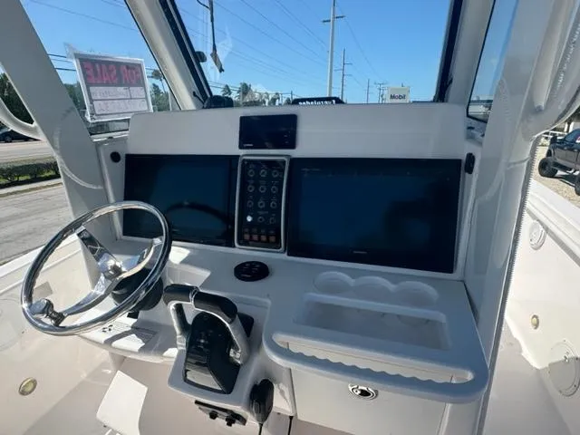 Slide: The Image of 2015 Everglades 295 Center Console boat dashboard with steering wheel and navigation screens. - 6