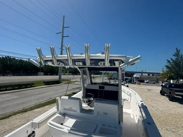 Slide: The Image of 2015 Everglades 295 Center Console boat with rod holders, parked on gravel lot. - 9