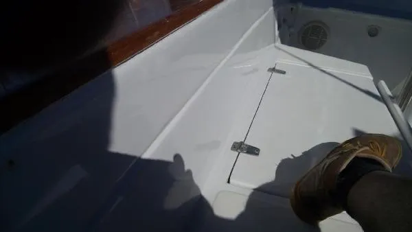 Slide: The Image of Interior view of a 1993 Columbia Cutter boat, featuring a white compartment with a hinge. - 14