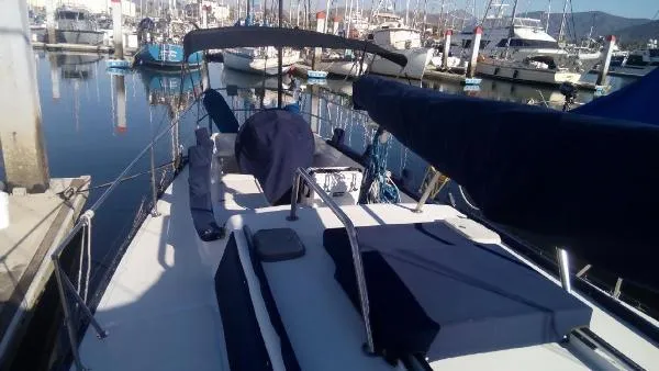 Slide: The Image of Sailboat docked at marina, Columbia Cutter 1993 model, with covered deck and visible masts. - 16
