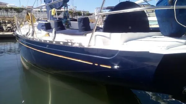 Slide: The Image of Sleek 1993 Columbia Cutter sailboat docked in marina, reflecting on calm water. - 18