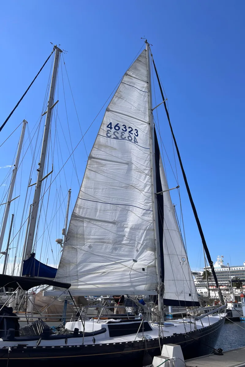 Slide: The Image of Sailboat docked at marina, Columbia Cutter 1993 model, with tall mast and white sails. - 24