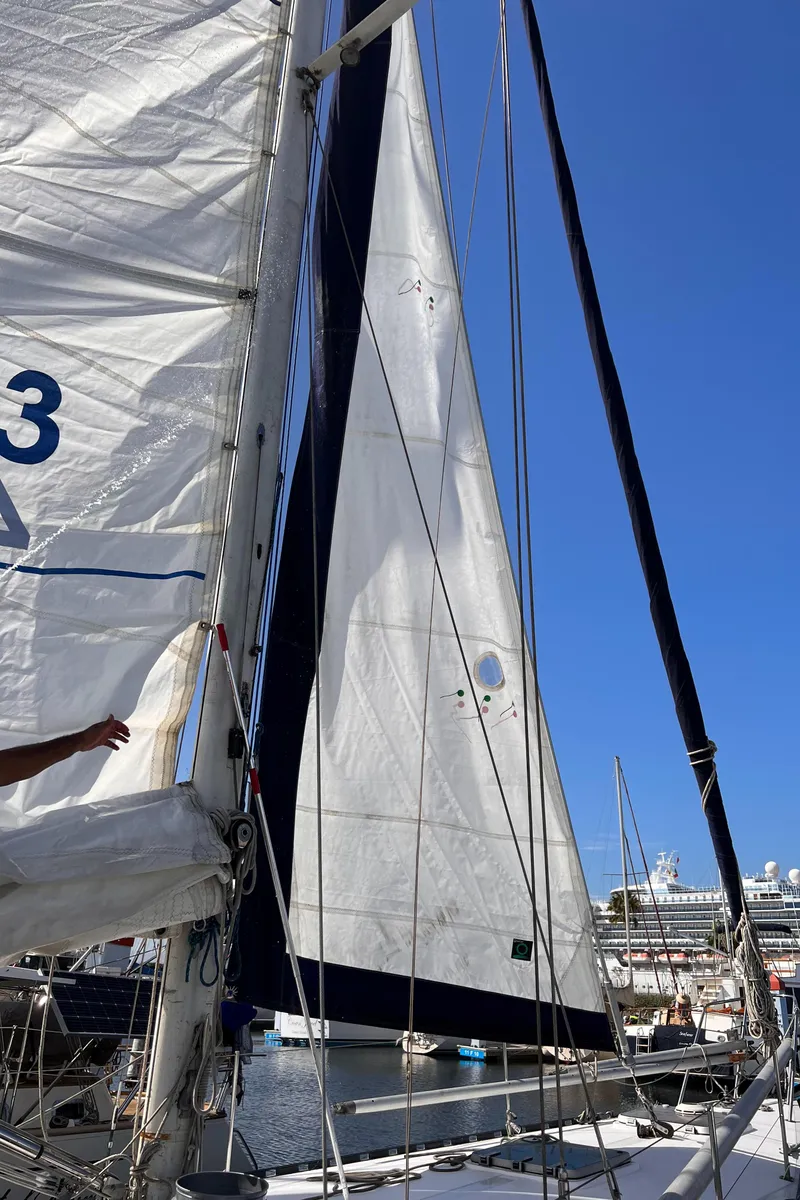 Slide: The Image of Sailboat with white sails docked at marina, Columbia Cutter 1993 model. - 25