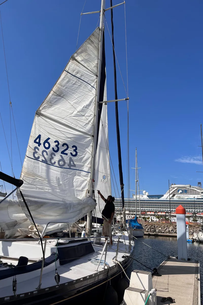 Slide: The Image of Sailboat Columbia Cutter 1993 docked, with sails raised, under clear blue sky. - 26