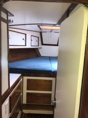 Slide: The Image of Interior of a 1993 Columbia Cutter sailboat with wood accents and a cozy sleeping area. - 28