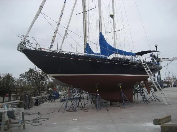 Slide: The Image of Sailboat on dry dock, Columbia Cutter 1993, with blue sails and ladder access. - 3
