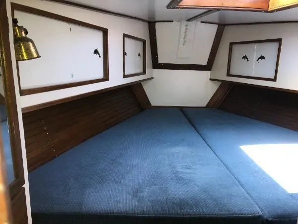 Slide: The Image of 1993 Columbia Cutter interior with blue cushions, wooden accents, and nautical decor. - 30